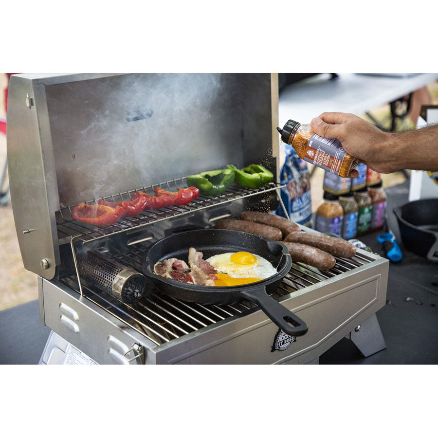 skillet with eggs and bacon on portable grill