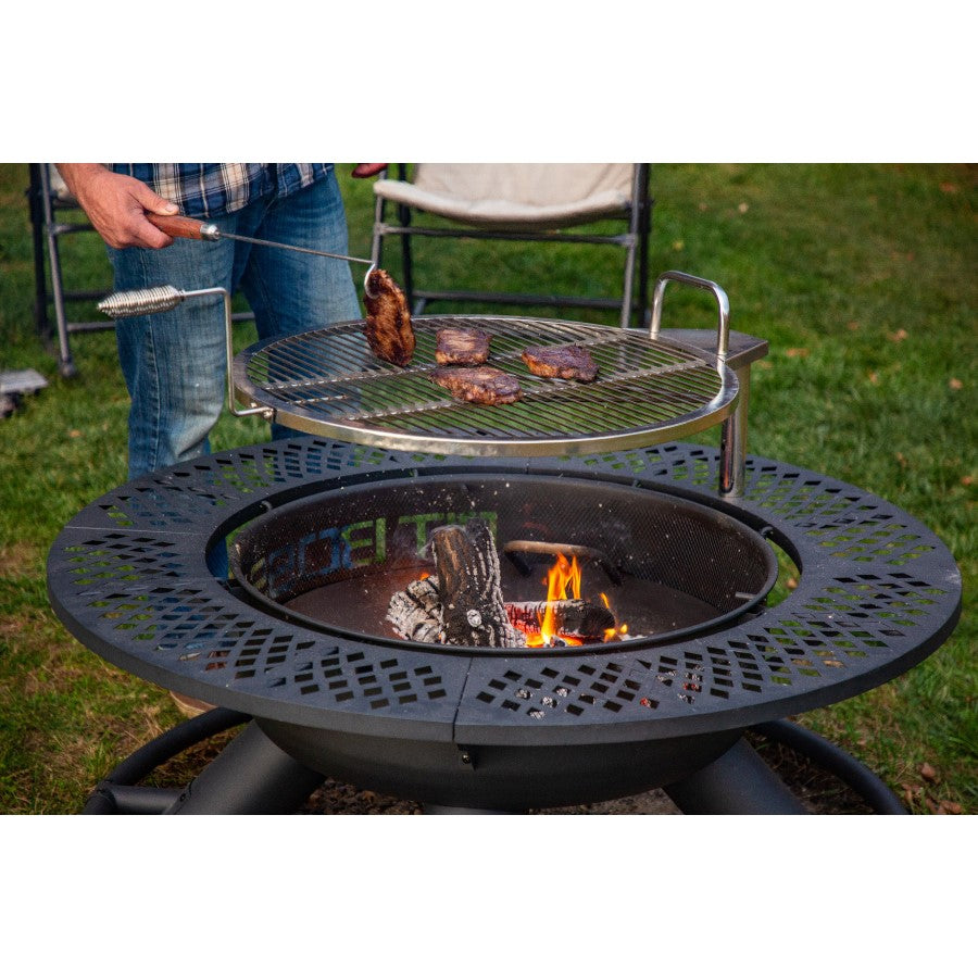 lifestyle_4, Black fire pit with round shape and black lettering: Pit Boss. Grilling meat on top of grate over fire pit