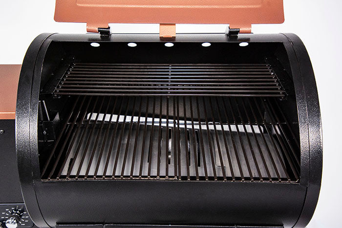 lifestyle_3, Orangeish-brown and black grill with silver accents and Pit Boss logo. Up close view of inside of grill and cooking grates
