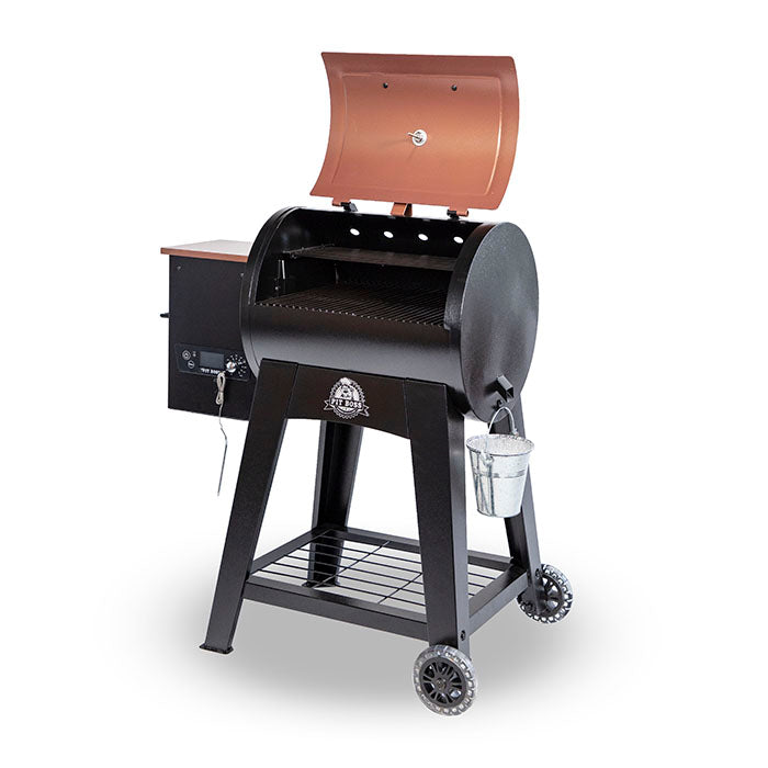 lifestlye_4, Orangeish-brown and black grill with silver accents and Pit Boss logo. Side angle view. Grill hood open.