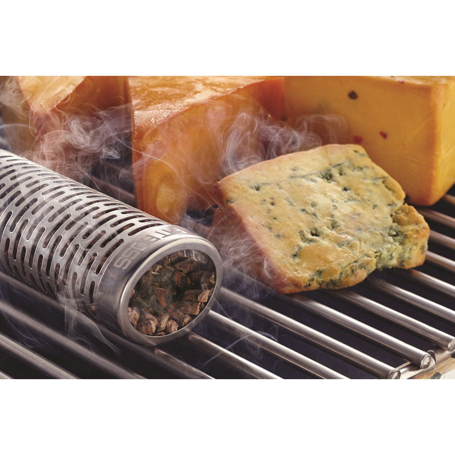 smoker tube with pellets inside next to cheese on grill